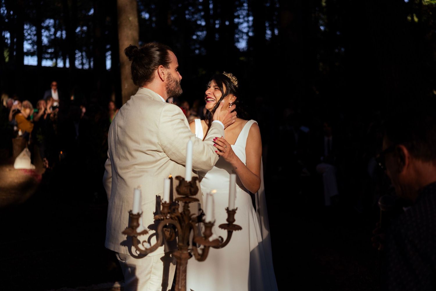 A romantic candlelit moment between newlyweds with an antique candelabra in the foreground.