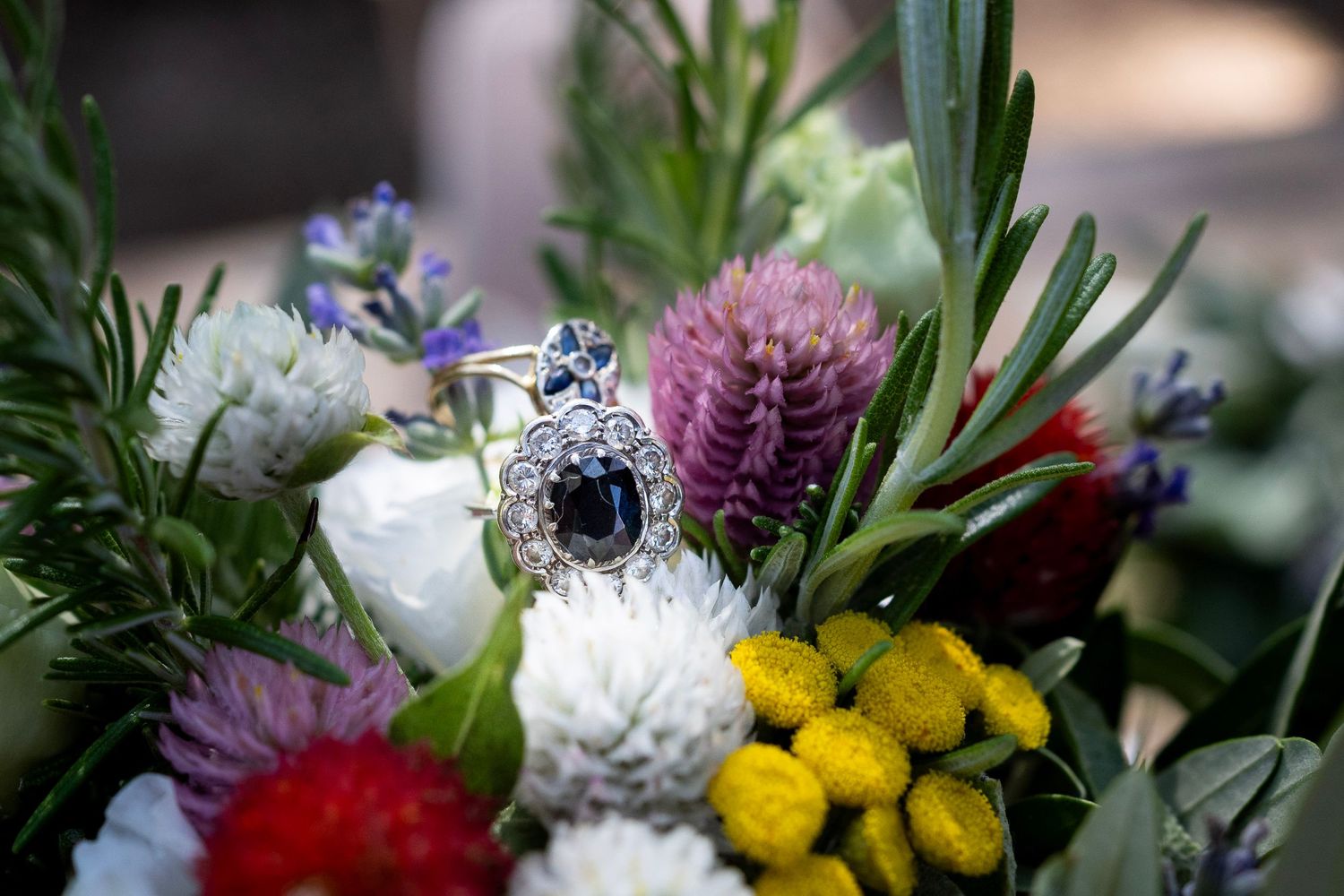 Vibrant wedding bouquet with white, purple, and yellow flowers in close-up detail.