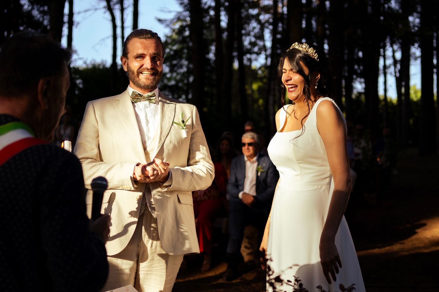 A couple celebrates during their outdoor forest wedding ceremony with tall pine trees in background.