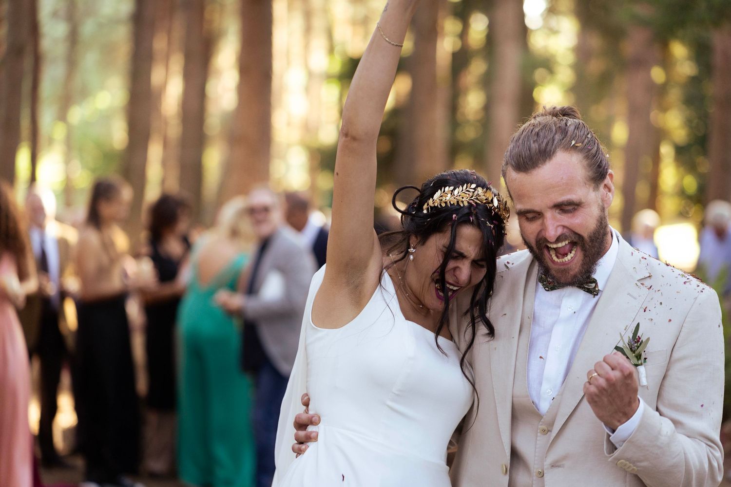 Two newlyweds celebrating with joy during their outdoor forest wedding ceremony.