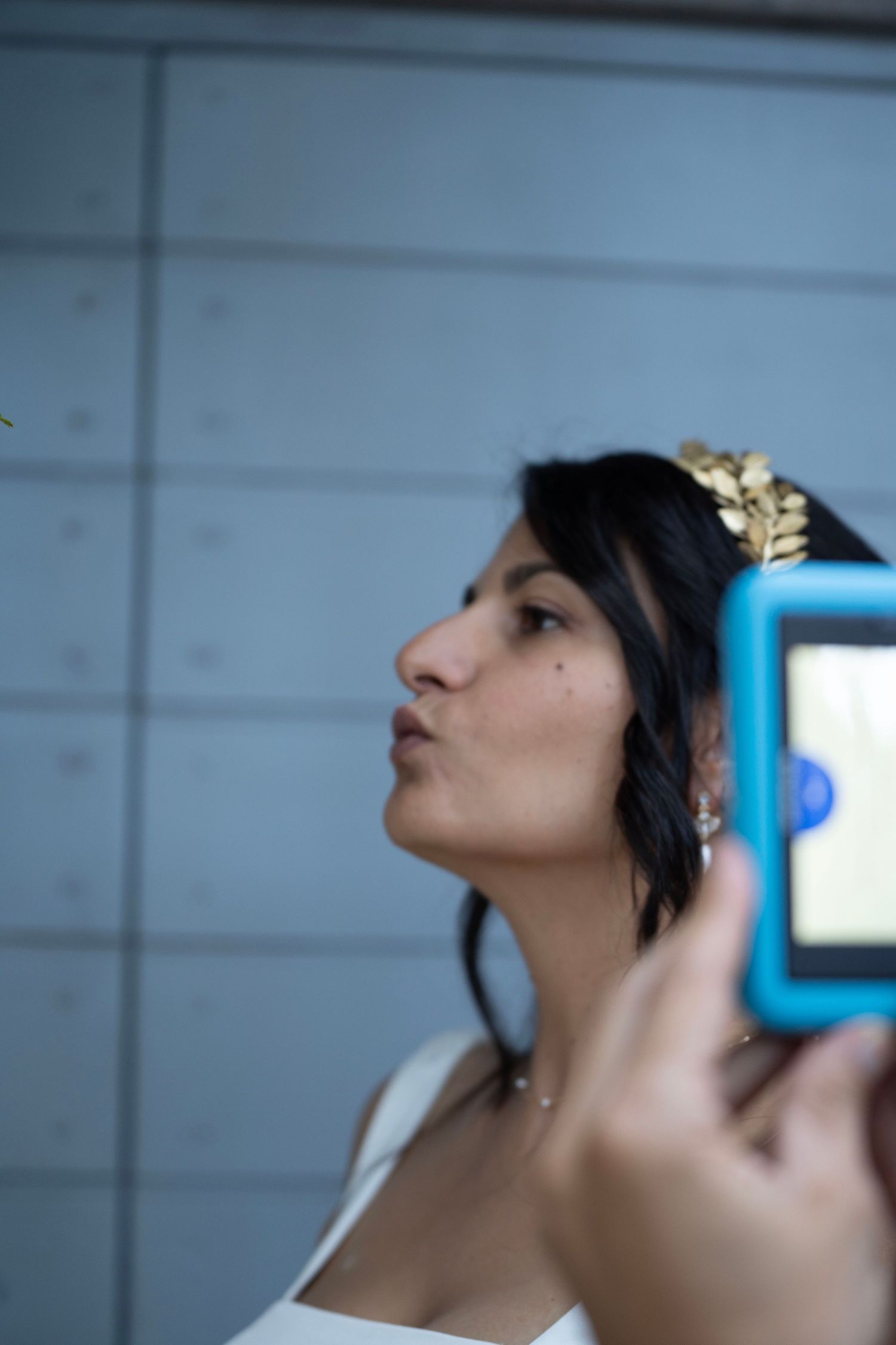 Profile view against blue wall with delicate crown accessory.
