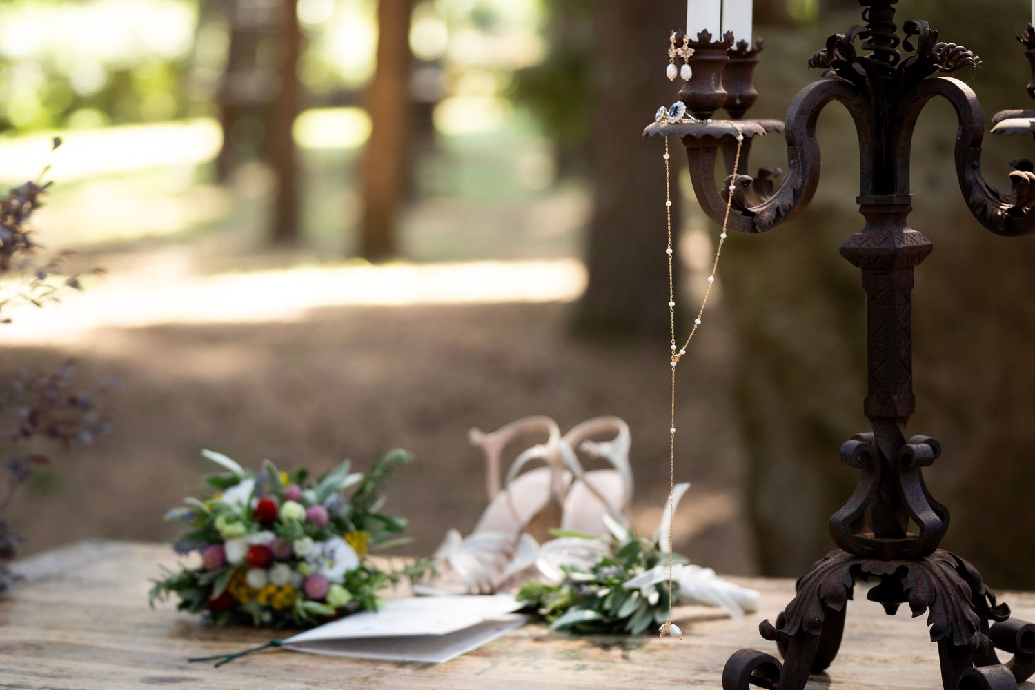 Vintage candelabra with wedding details and floral arrangements in soft focus.