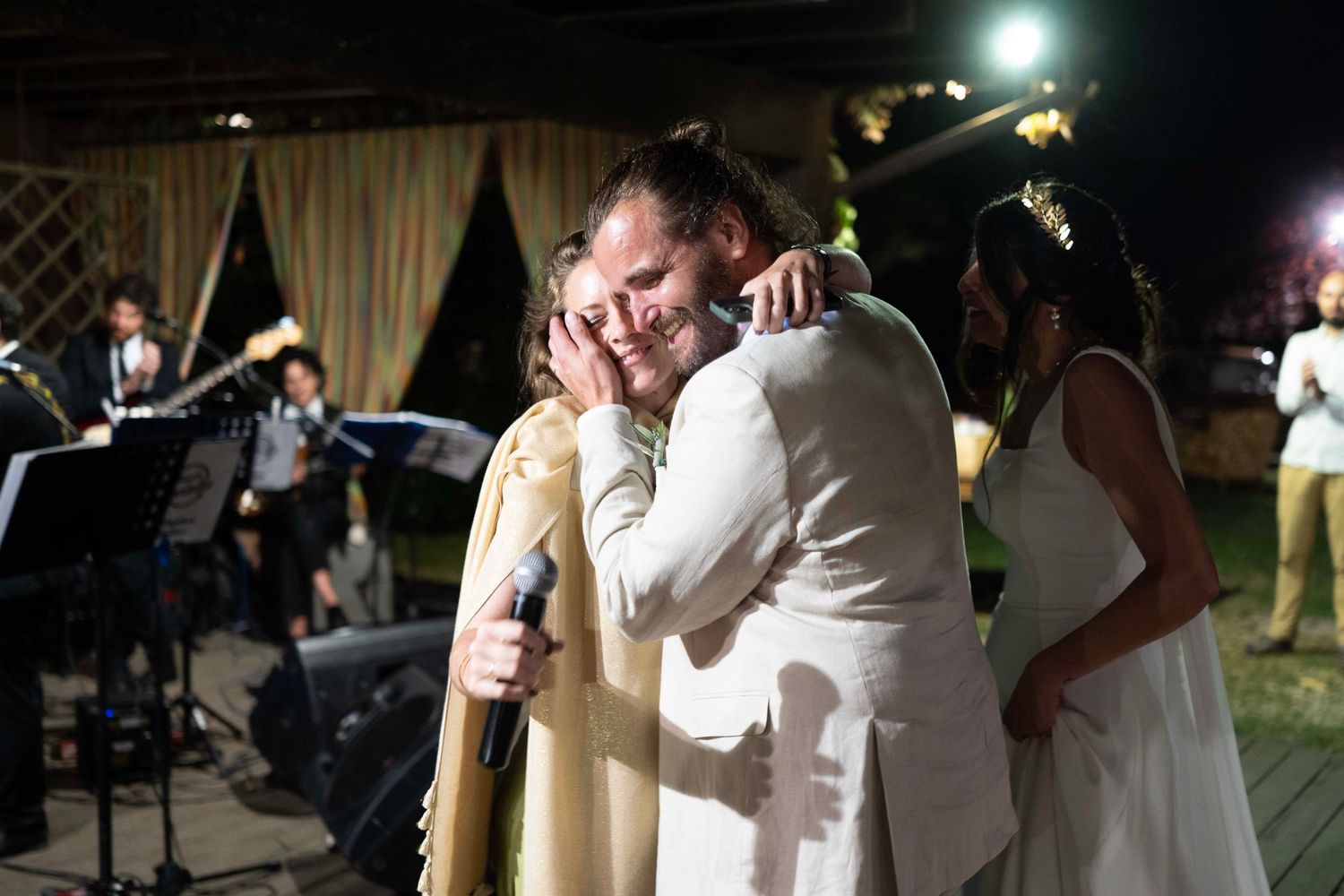 Wedding reception dance moment under outdoor evening lighting.