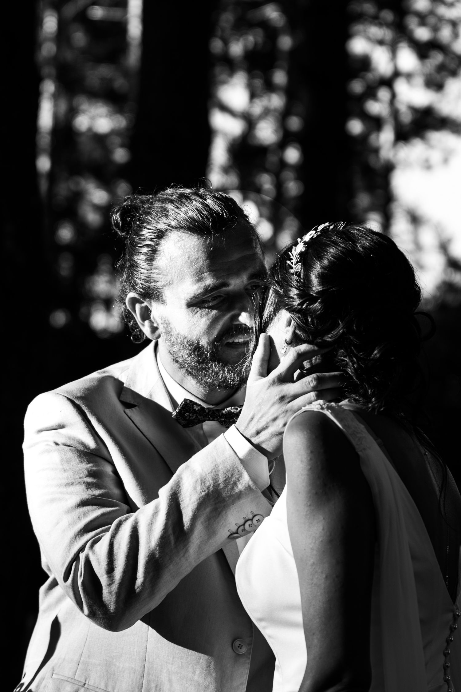 An intimate black and white portrait of a couple sharing a tender moment during their wedding.