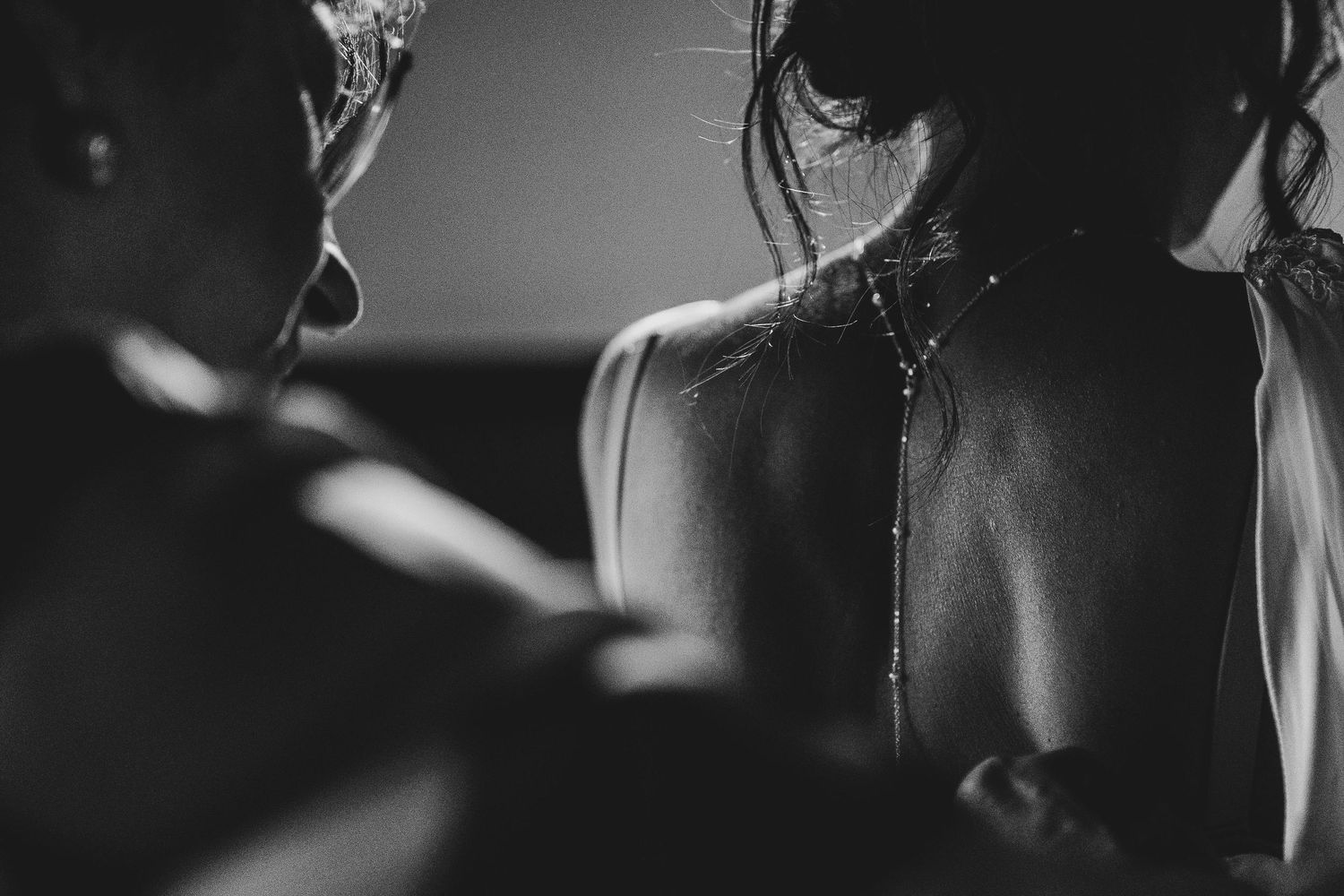 Artistic black and white close-up photograph showing silhouettes and dramatic lighting.