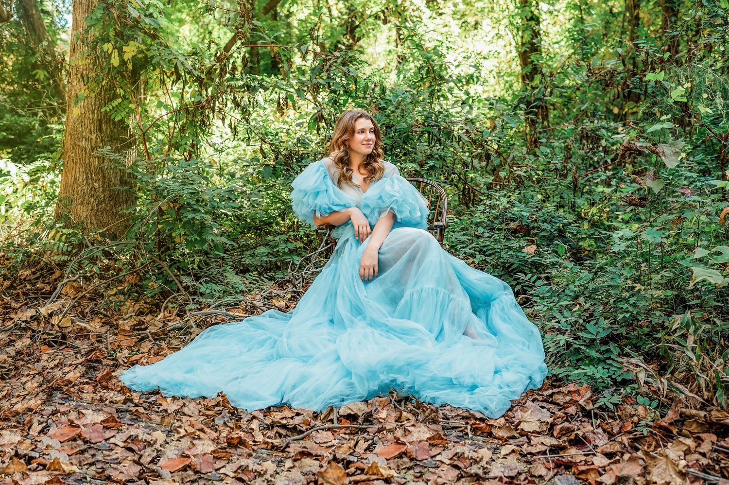 Ethereal light blue tulle dress captured in natural forest environment.