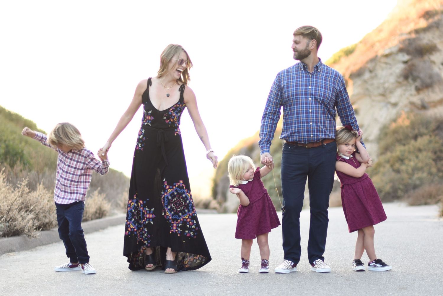 Family members walking together on a scenic dirt path at sunset.