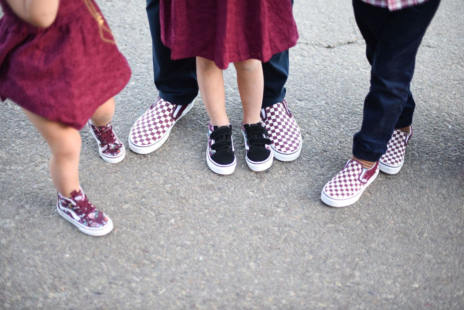 Row of fashionable shoes and feet arranged in a creative group photo on pavement.