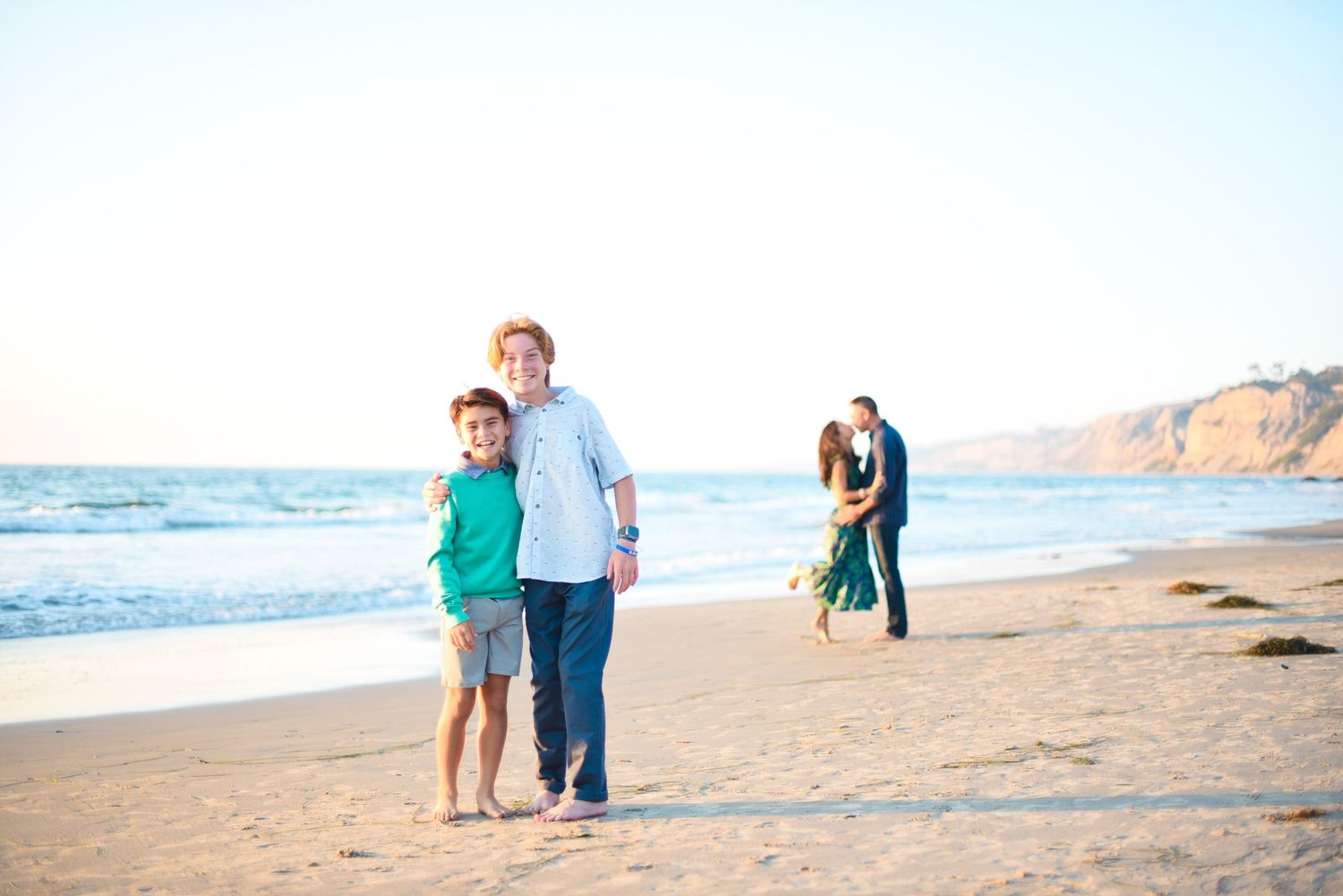 Family enjoying quality time together walking and playing on a sunny beach.