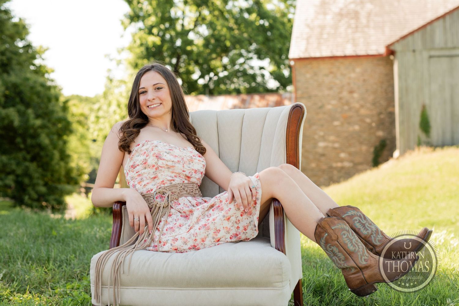 Casual portrait in vintage armchair wearing floral dress and western boots.