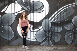 Fashion portrait against black and white floral street art mural.