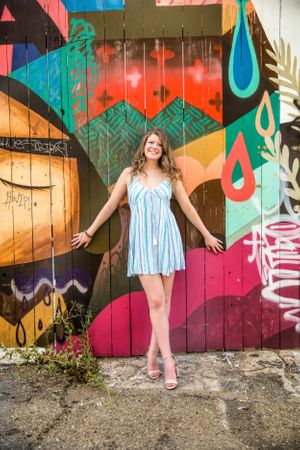 Summer fashion portrait against colorful geometric street art mural.