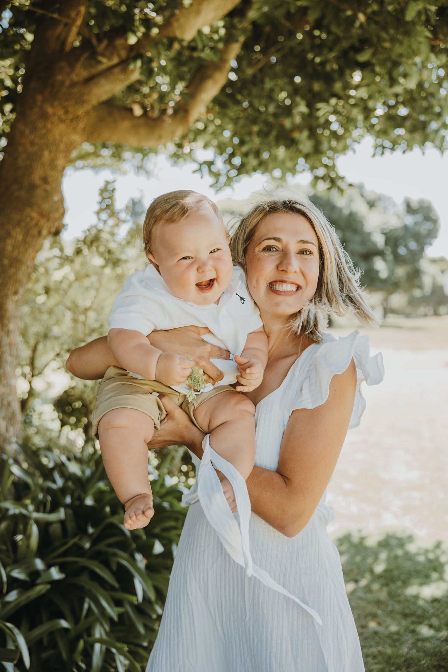 A joyful moment captured between parent and child in a sunny garden setting.
