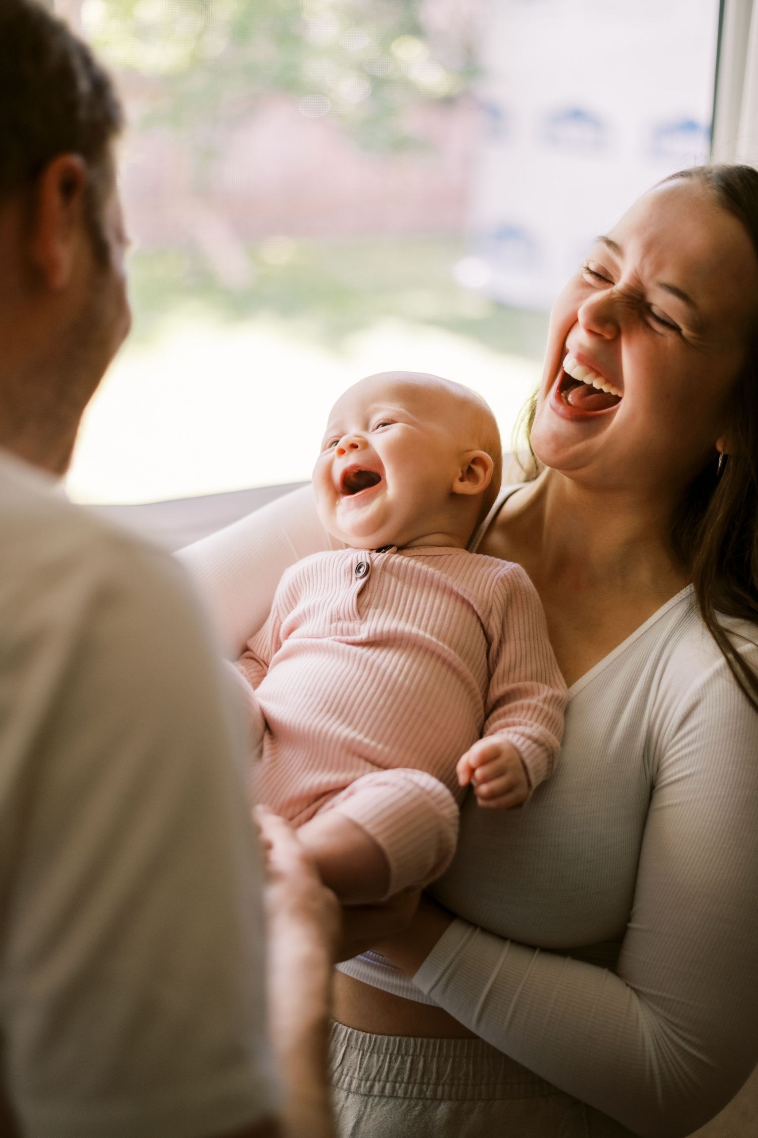 Joyful candid moment of shared laughter in soft natural light.