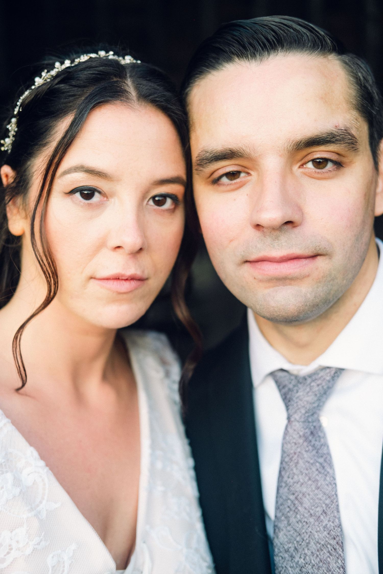 Close-up portrait of bride with floral crown and groom in suit on wedding day. Lakeville, Ma Miranda Photo & Co