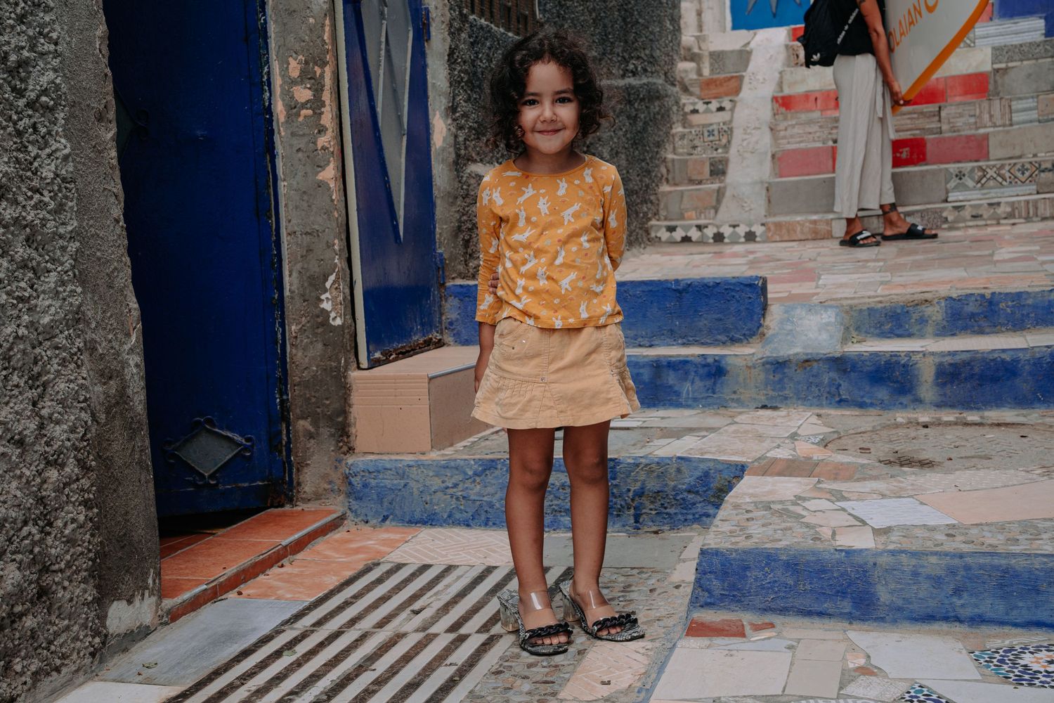 A painted doorway with blue trim and stone steps in a Mediterranean neighborhood.