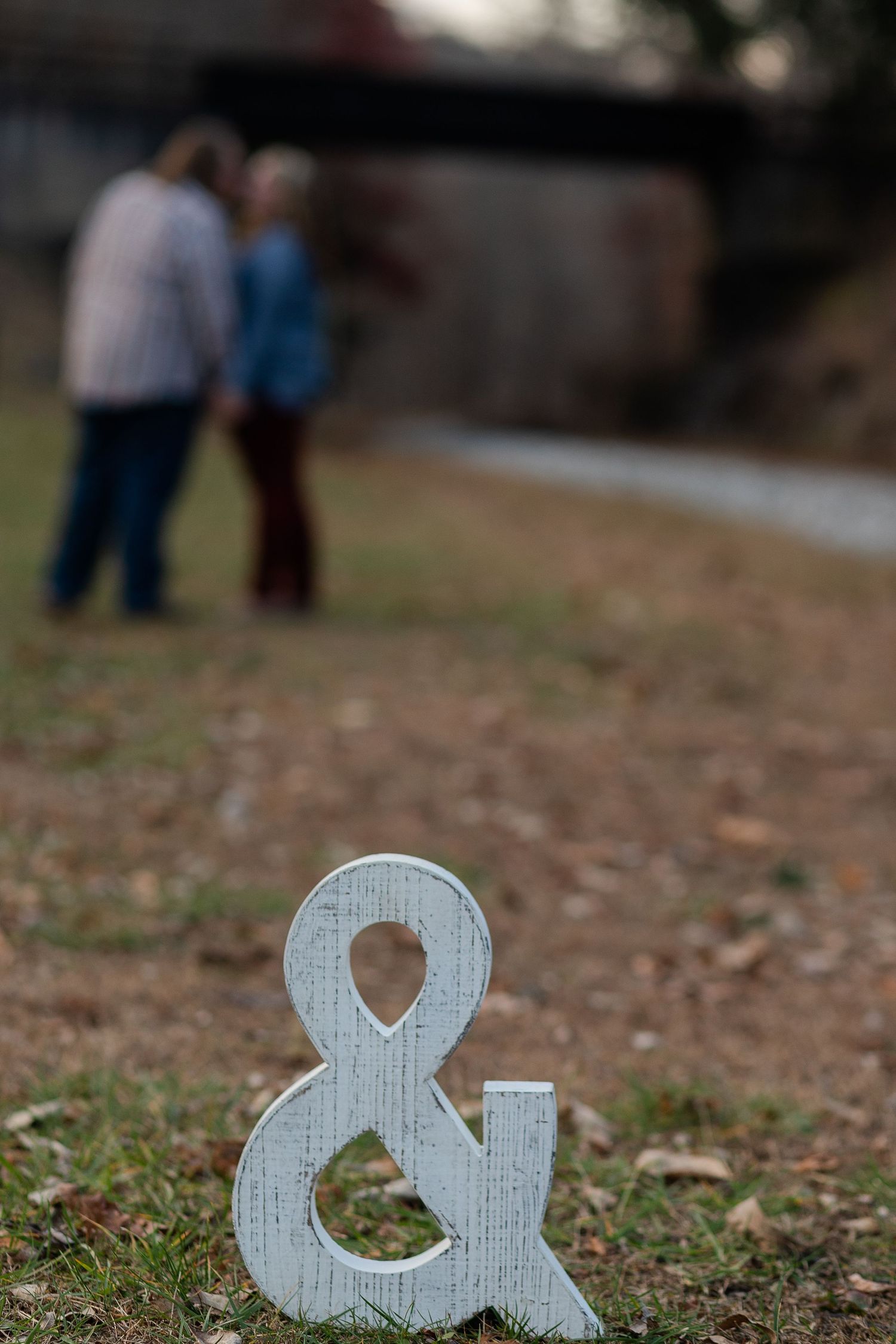 A decorative ampersand symbol with a couple blurred in the background.