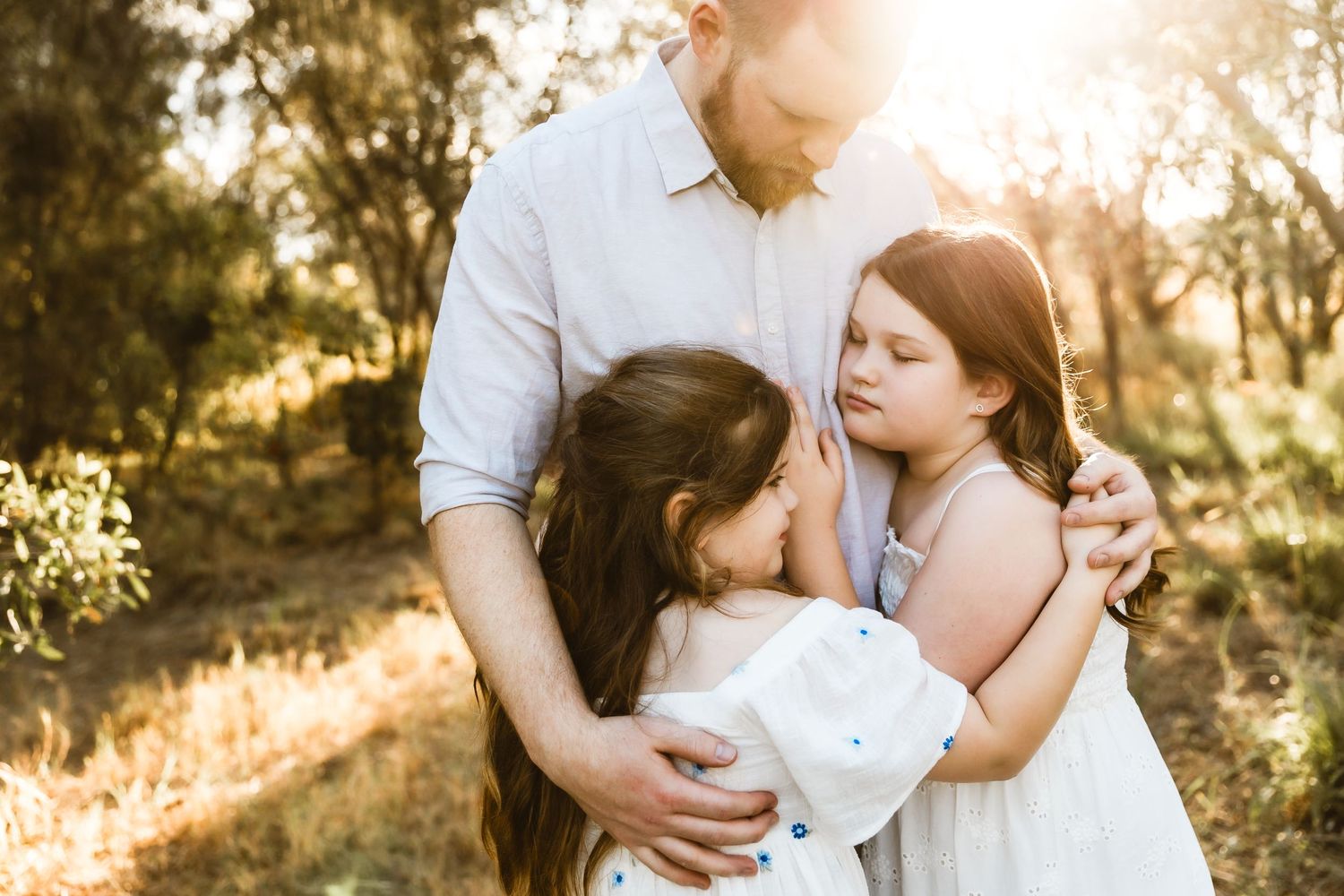 Father embraces his two daughters during a Brisbane family photo shoot