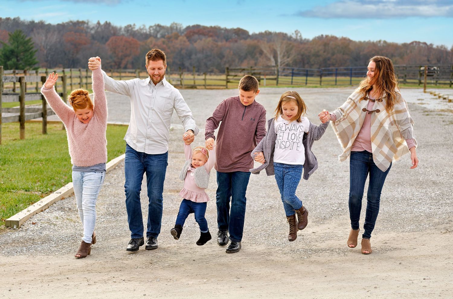 Parents and children share laughter outdoors during a warm, rustic family photo session in Mid-Missouri.