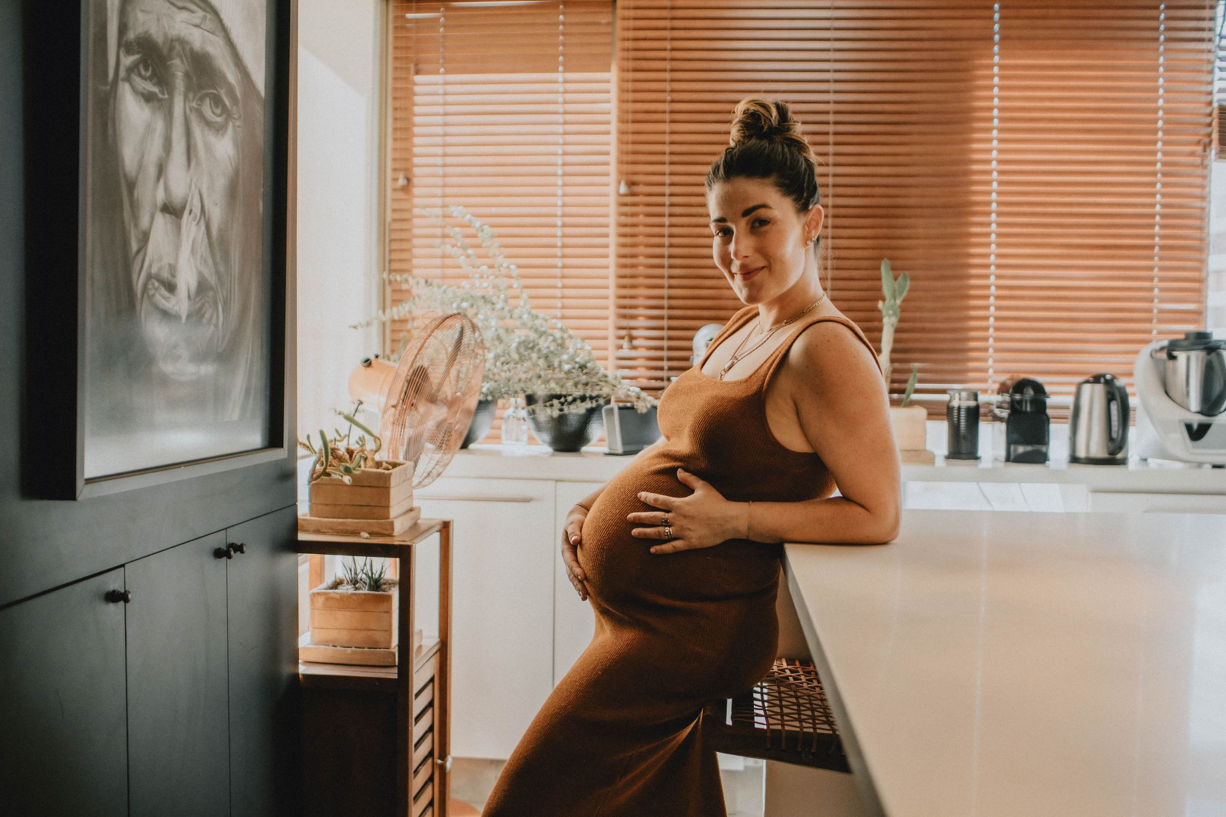Solo indoor maternity session with a mother, emphasizing natural light and intimate pregnancy moments.