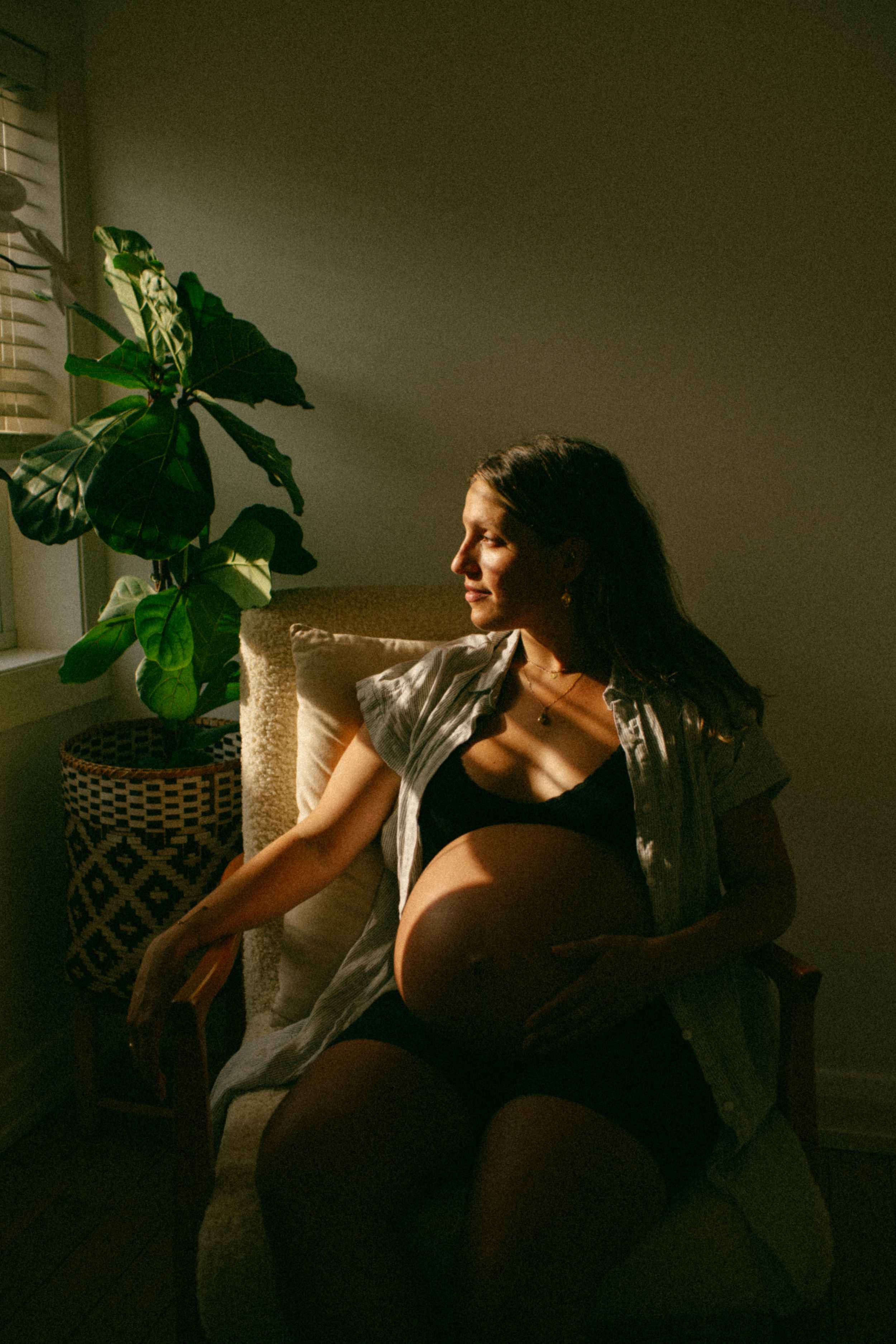 Artistic maternity portrait session in Sydney & Northern Beaches, capturing the mother-to-be with dramatic light and shadow, highlighting el