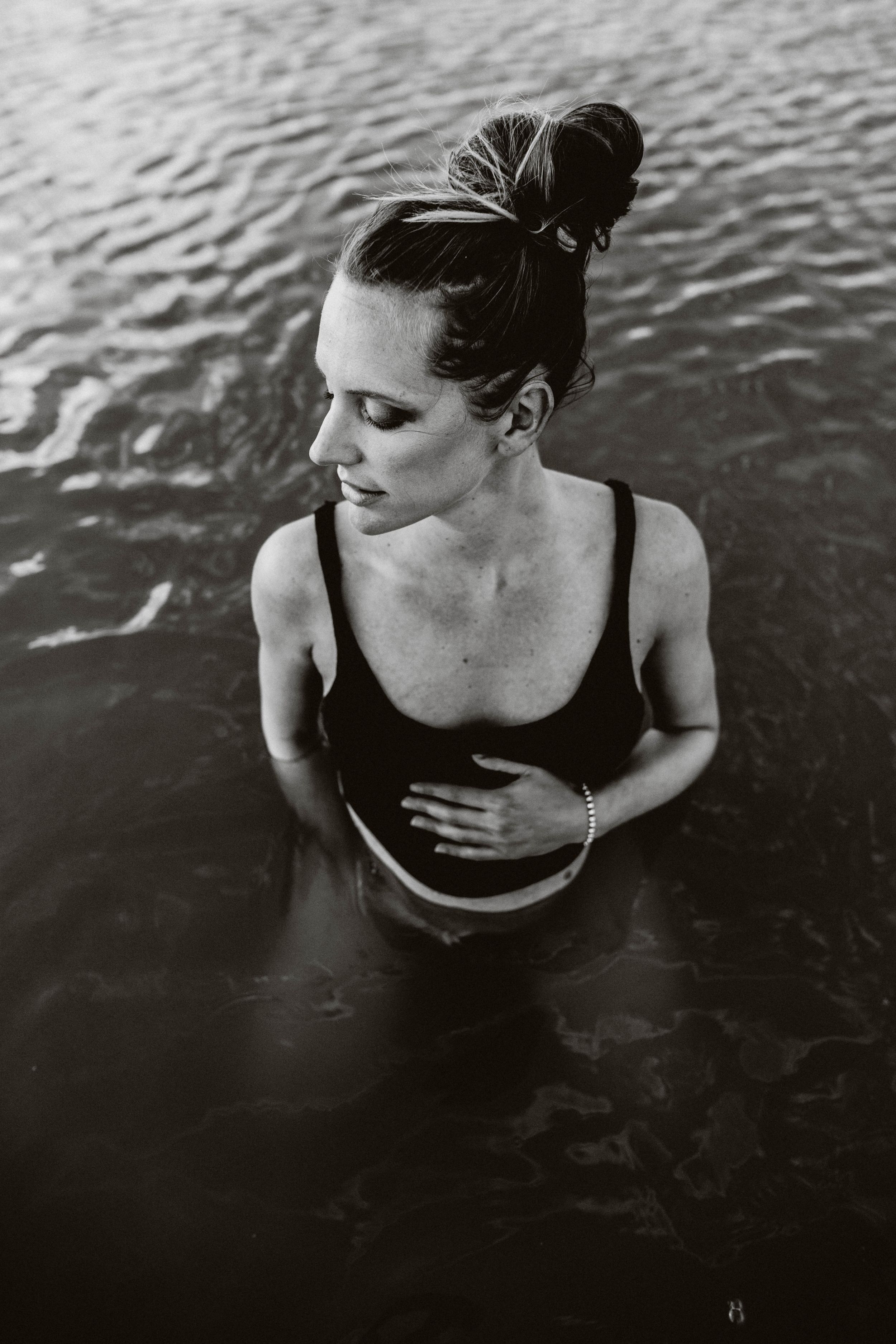 Maternity photography session in Sydney & Northern Beaches, mother standing in water, capturing elegant, tender, and natural moments of preg