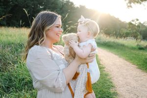 Sweet bonding moment captured on a sunlit dirt path surrounded by golden grass at sunset.