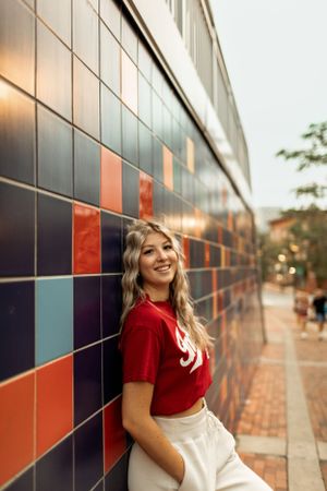 Casual portrait against a colorful geometric tiled wall in urban setting.