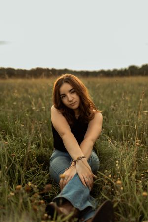 Artistic portrait taken in a serene meadow during golden hour.
