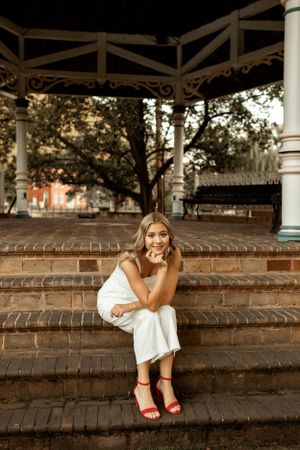 Sunset portrait on brick steps under decorative gazebo structure.