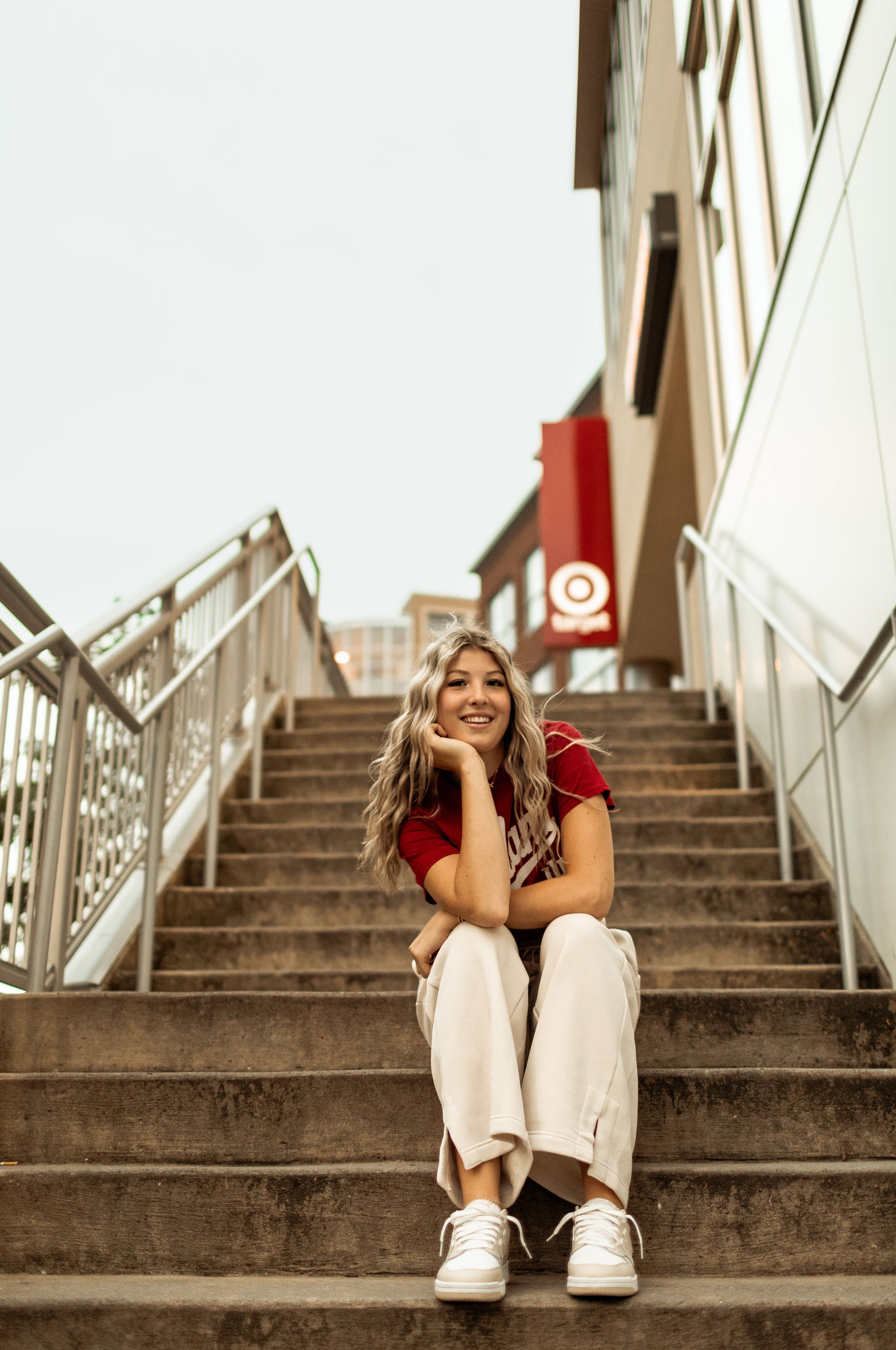 Candid moment captured on concrete stairs with person in red shirt and white pants.