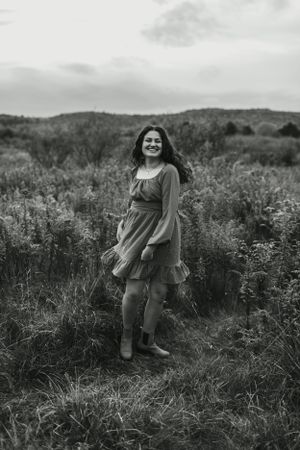 A black and white portrait in a wild meadow wearing a romantic dress.