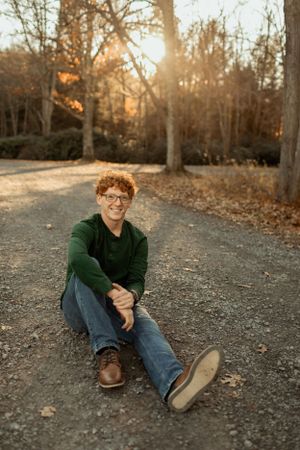 Autumn sunset portrait on a forest path with warm golden lighting.