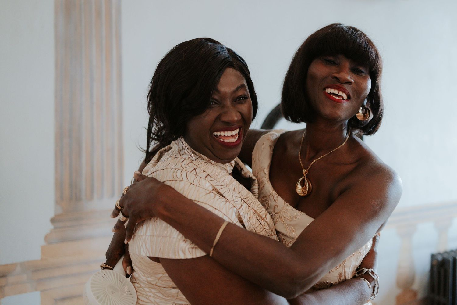 Joyful wedding day moment captures candid laughter and embraces.