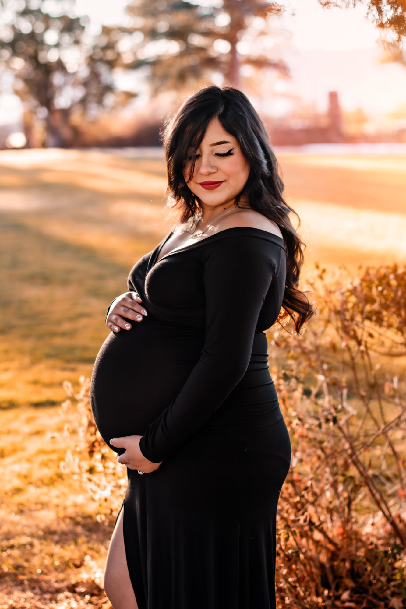 woman posing for her maternity photos in the highlands ranch mansion courtyard