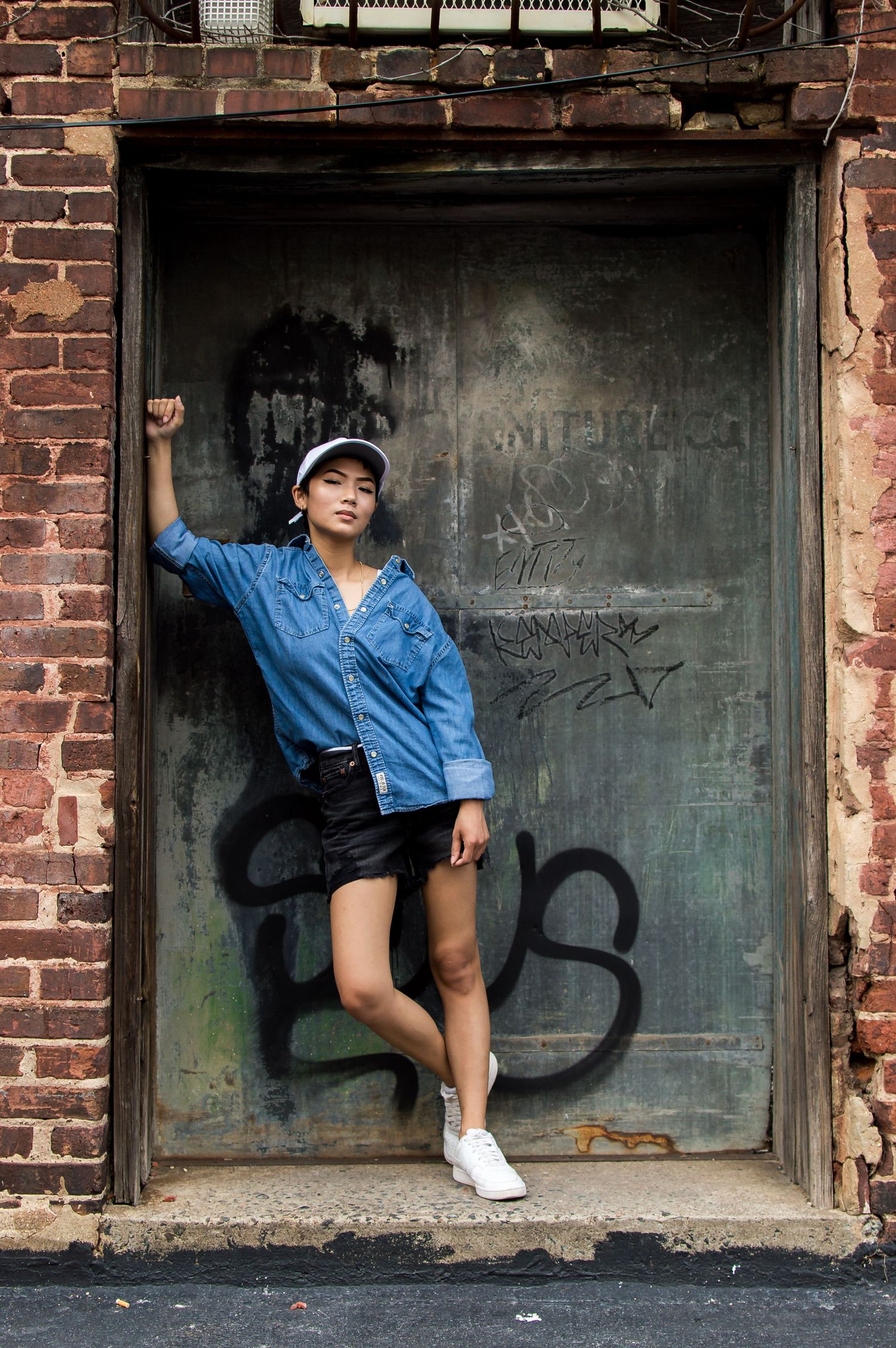 Girl leaning up against a wall covered in graffiti