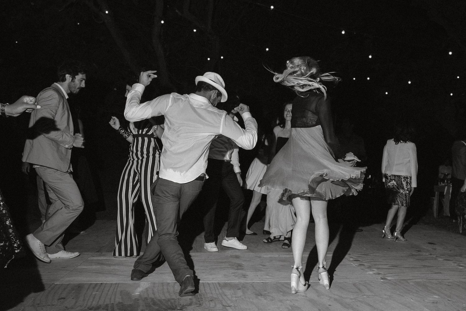 Black and white wedding celebration with couple walking through guest tunnel.
