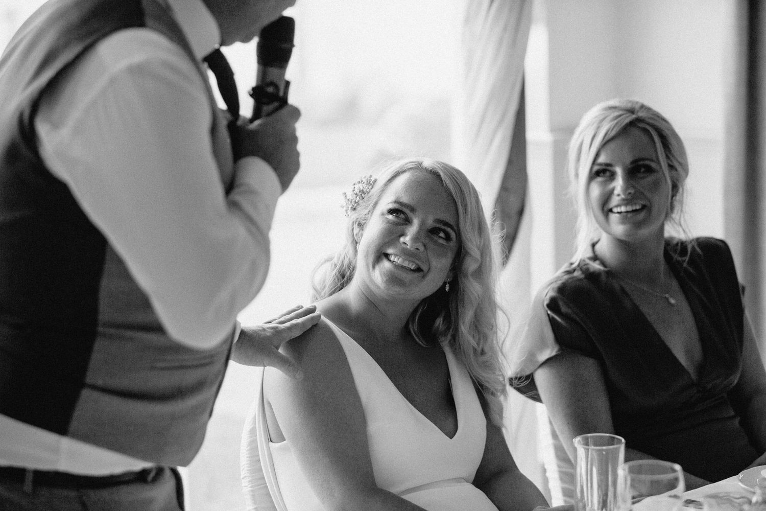 Black and white photo of wedding reception speech and reactions.