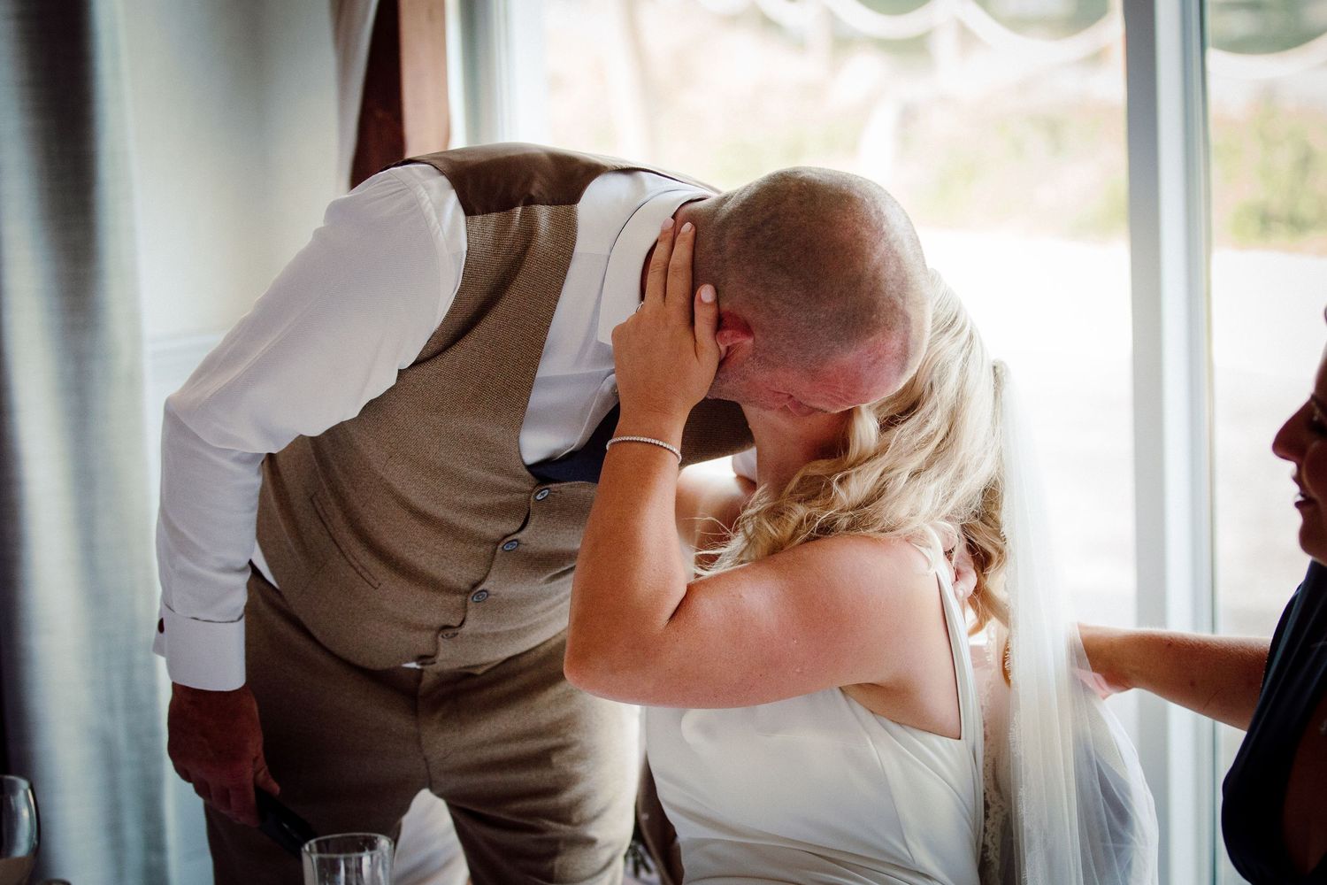 Emotional moment shared between two people during wedding reception.