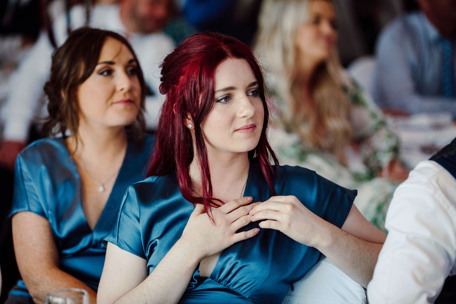 Guests in blue dresses enjoy wedding reception celebrations.
