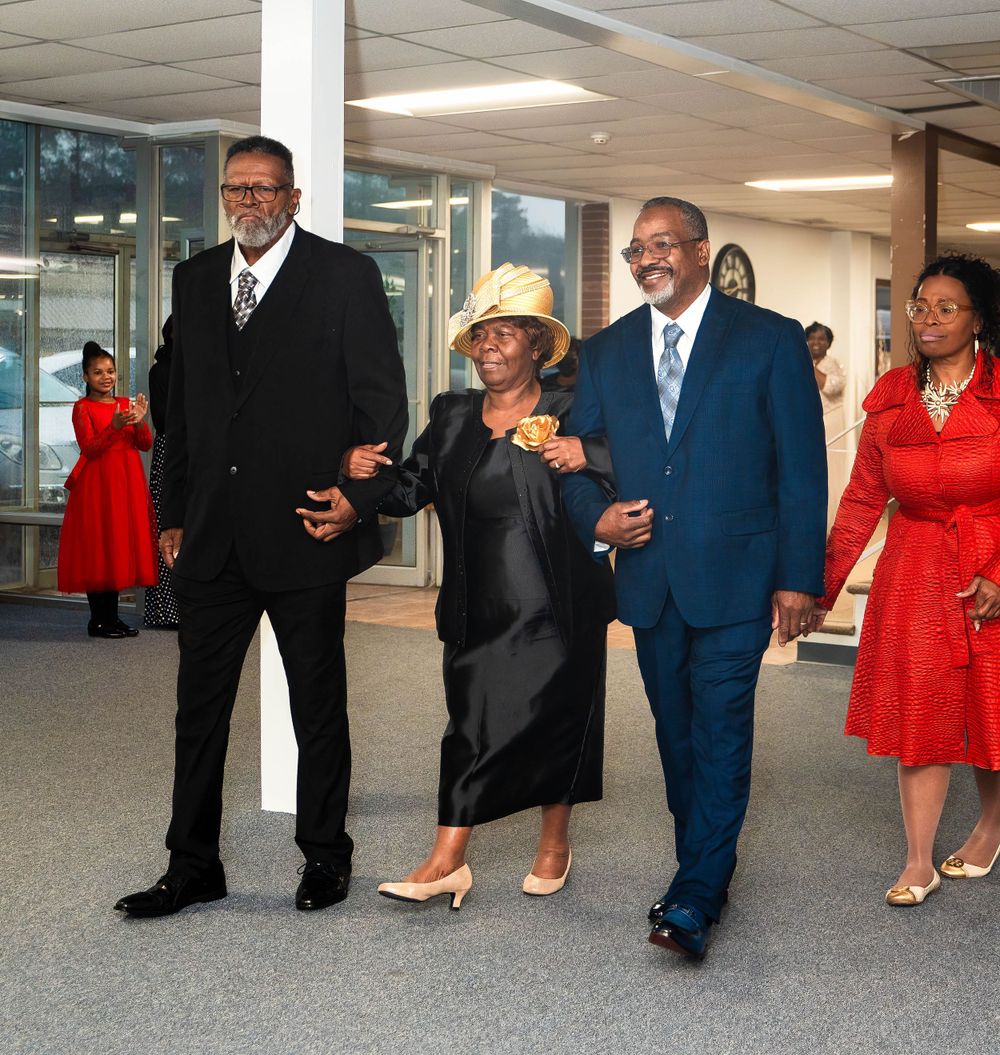 Group walking together in formal attire through an indoor space.
