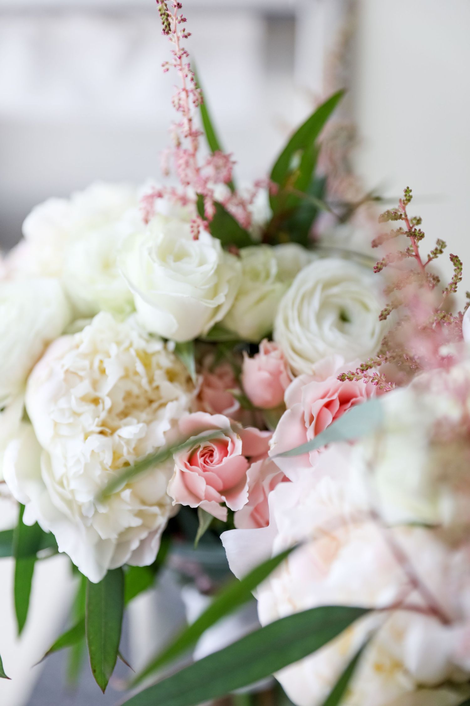 Elegant wedding bouquet with white and pink roses, delicate greenery and blush accents.