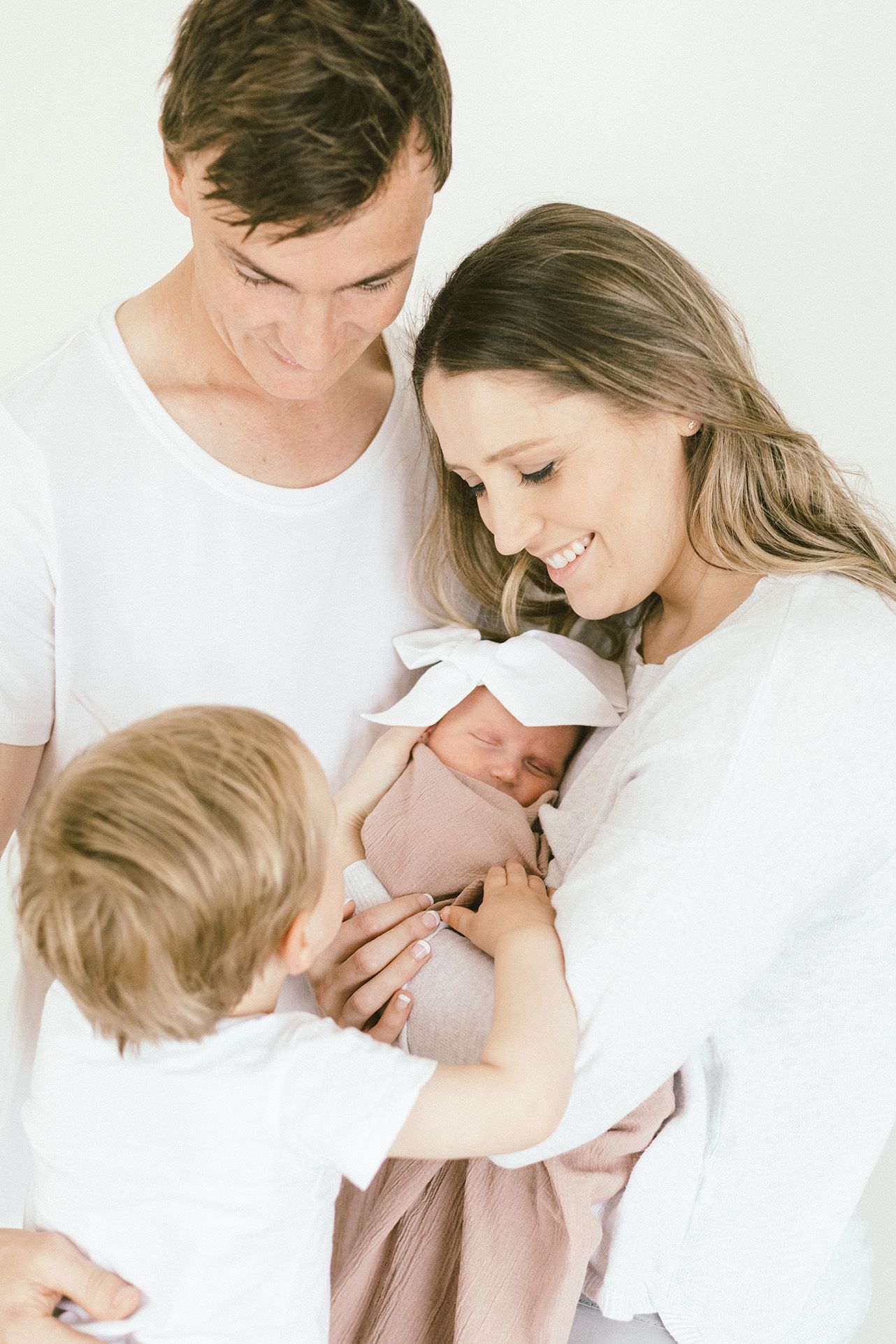 Tender family moment as parents and toddler bond with newborn.