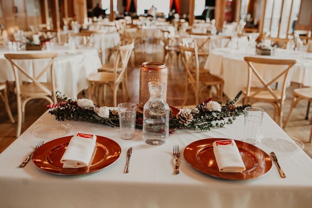 Wedding sweetheart table with copper charger plates, crystal glassware, and floral runner.