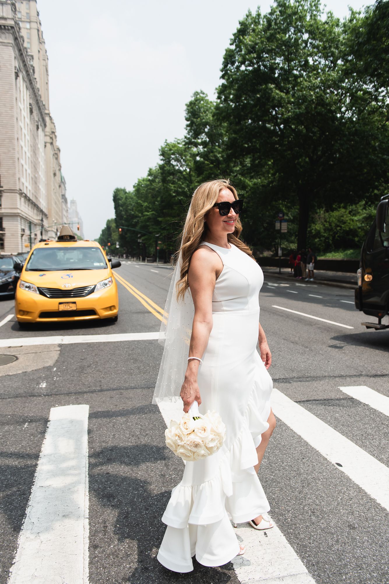Wedding photo shoot on New York City street with yellow taxi in background.