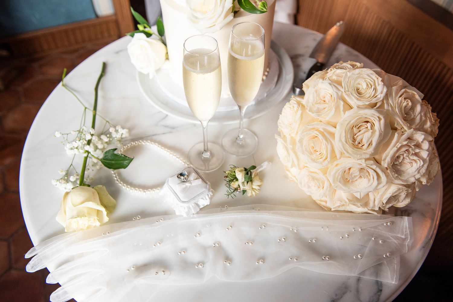 White roses and wedding decorations arranged on delicate white fabric.