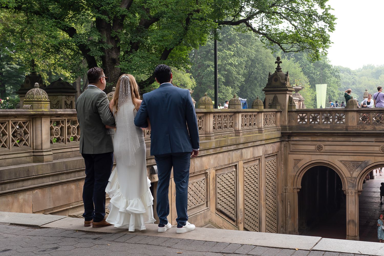 Wedding party walks along the historic Bethesda Terrace in Central Park.