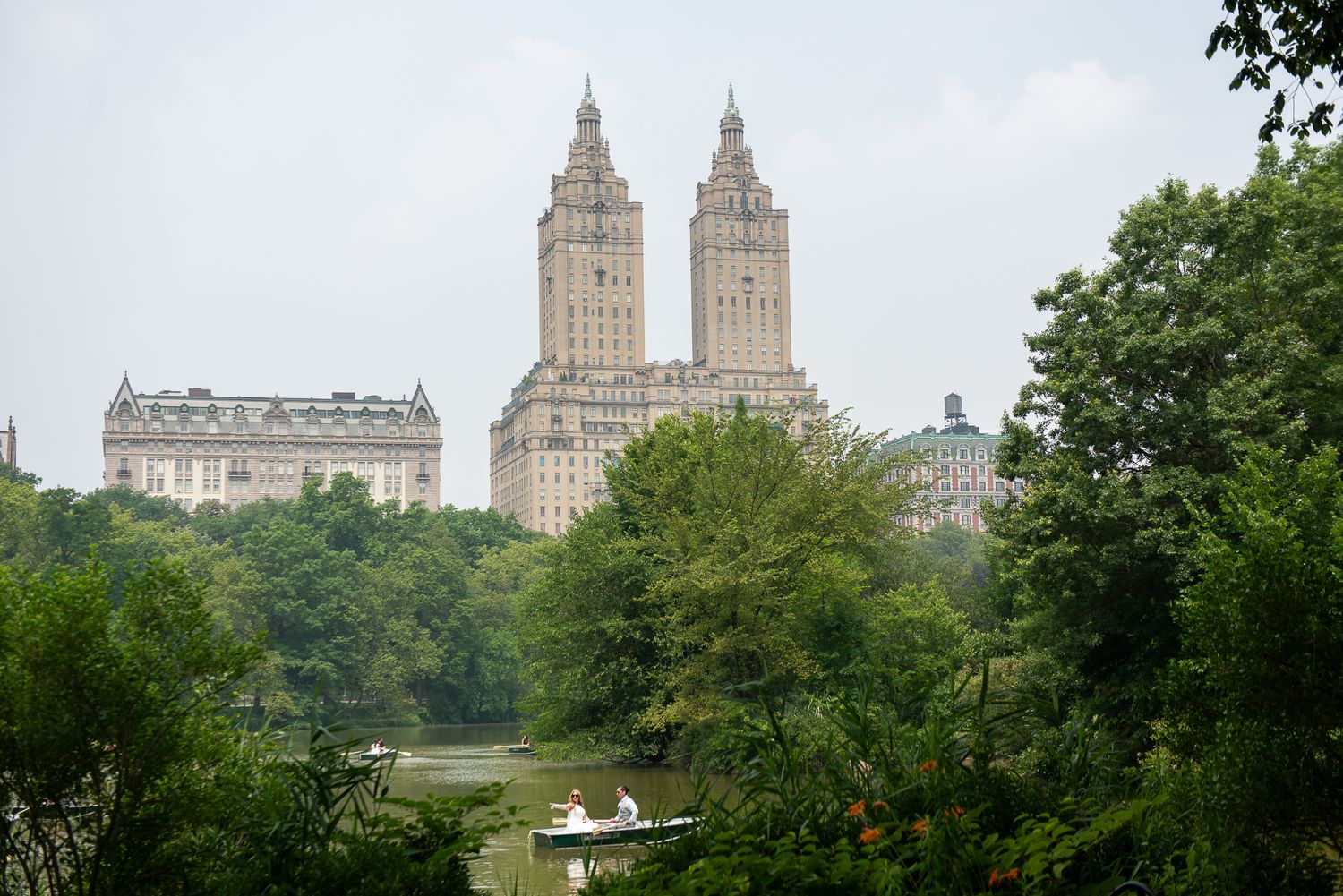 View of Central Park with the iconic San Remo building towers visible through lush green trees.