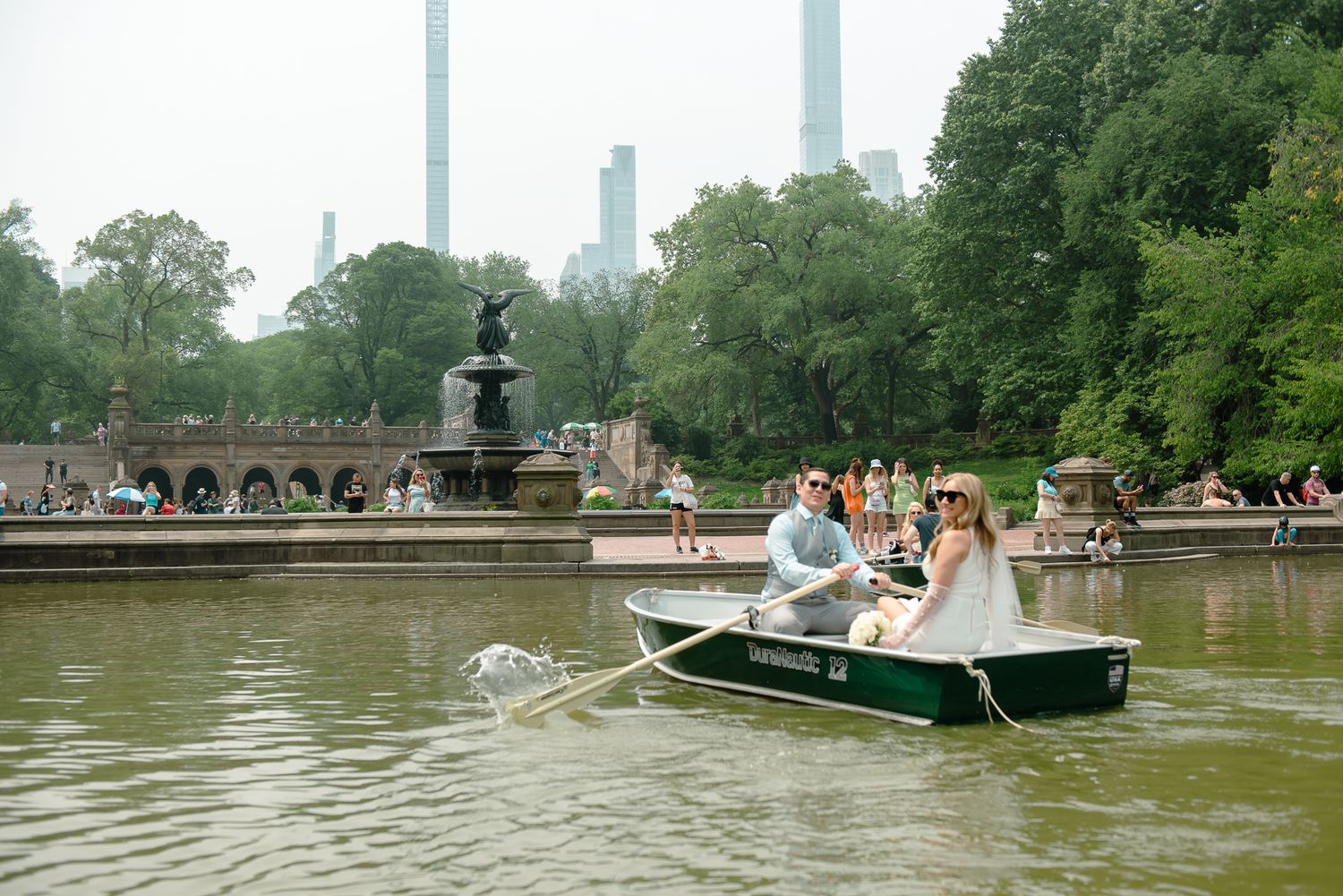 Scenic view of boats on The Lake in Central Park with Manhattan skyline in background.