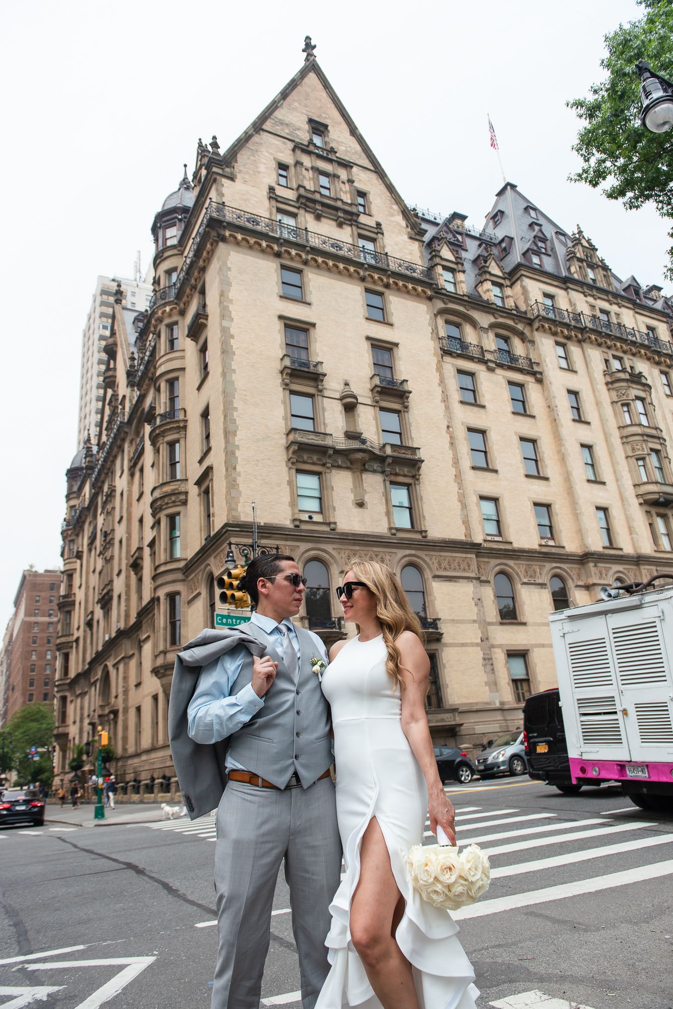 Wedding couple poses outside historic Dakota Building in New York City.
